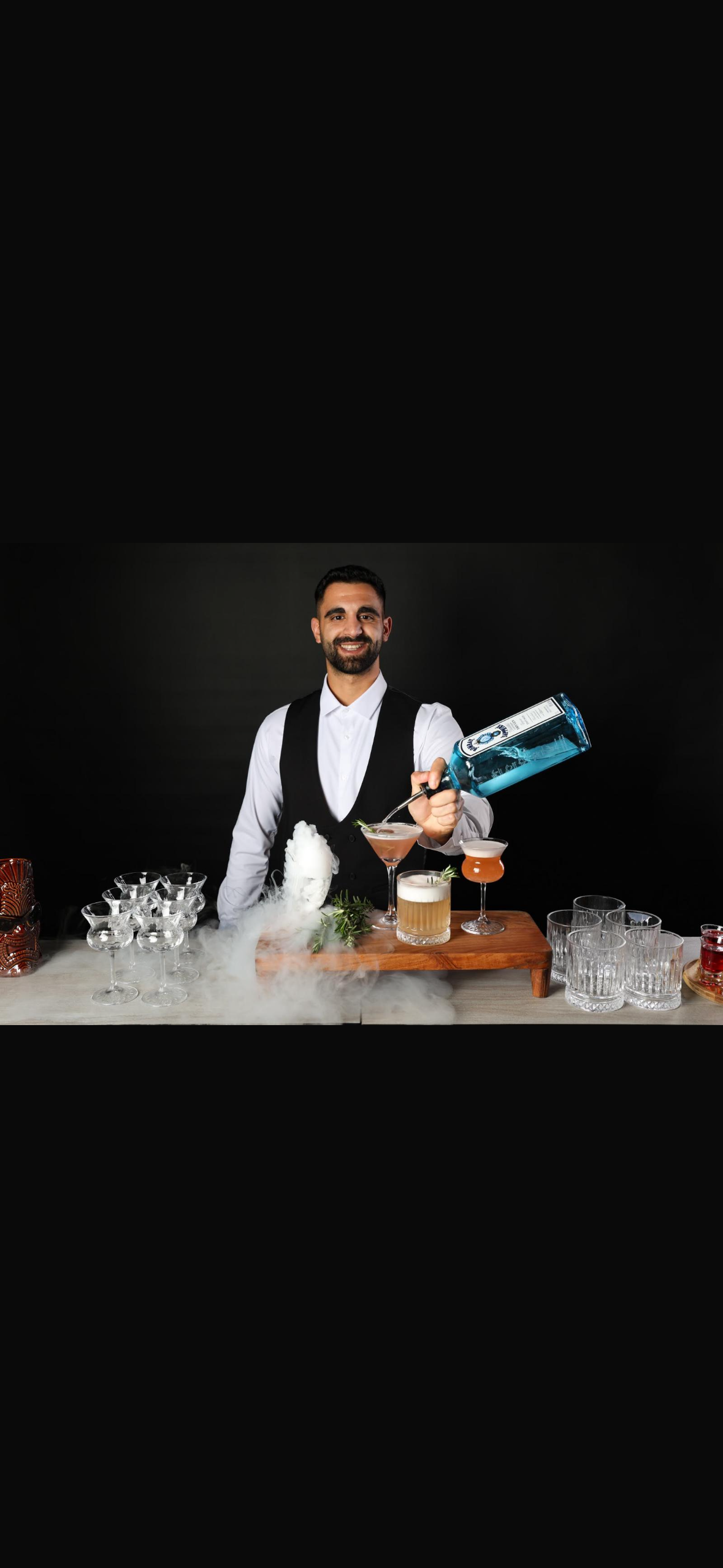 ברמן מוזג קוקטייל עם בקבוק כחול